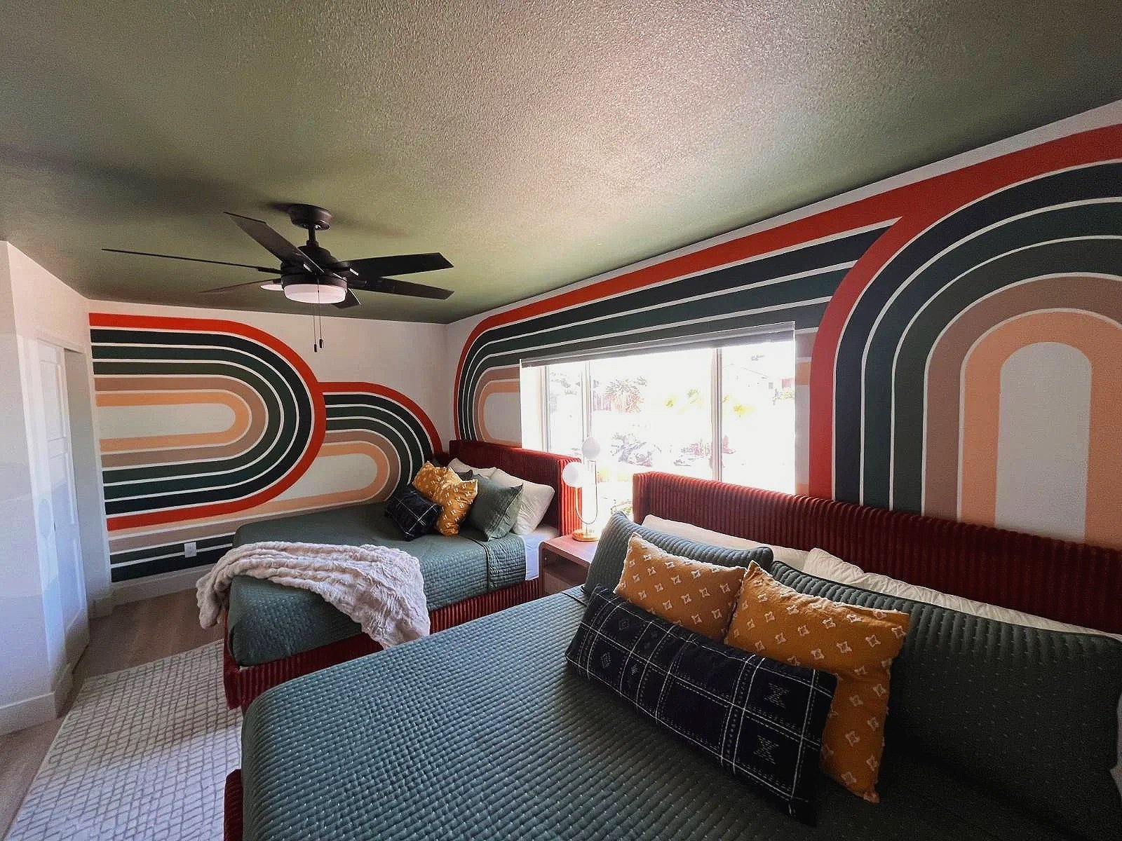 Custom retro rainbow arch accent wall mural by Jade Bamford Murals for a Scottsdale Arizona Airbnb.