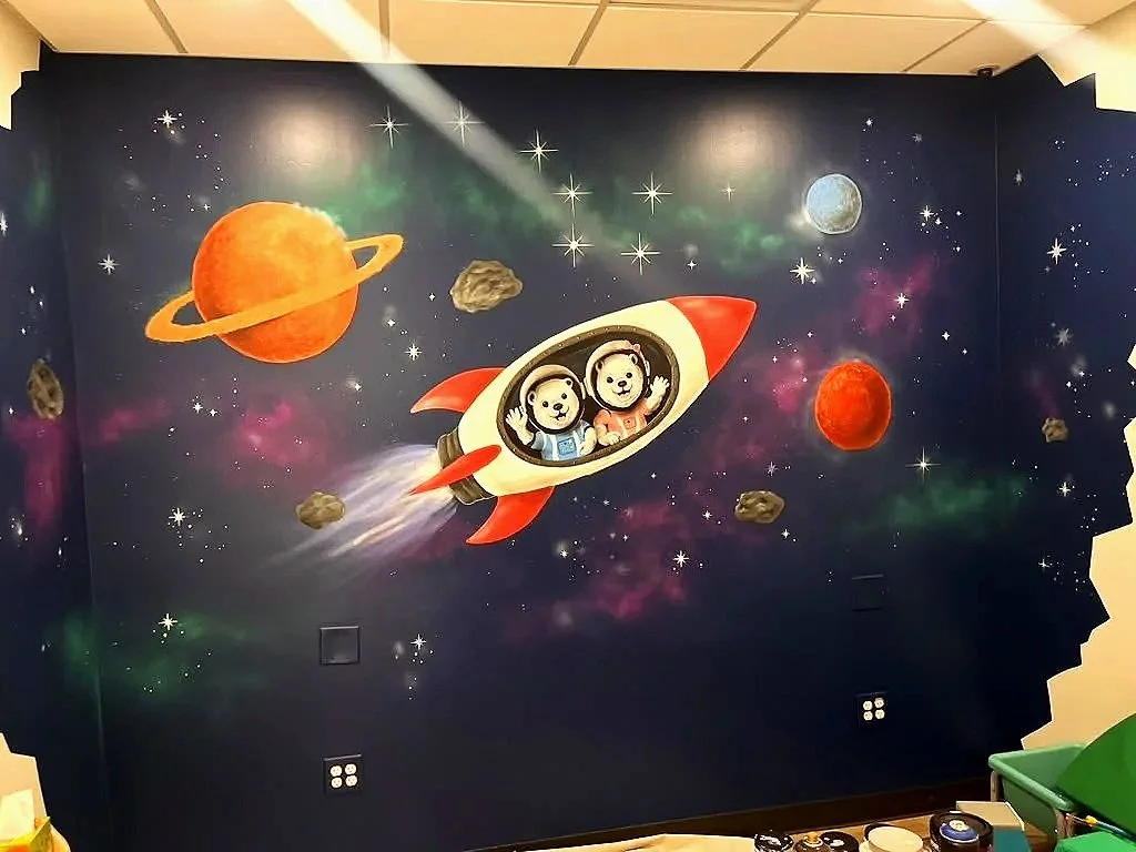 Custom space mural with astronaut bears and a rocket ship at Starlight Academy for Autistic Children in Mesa, Arizona