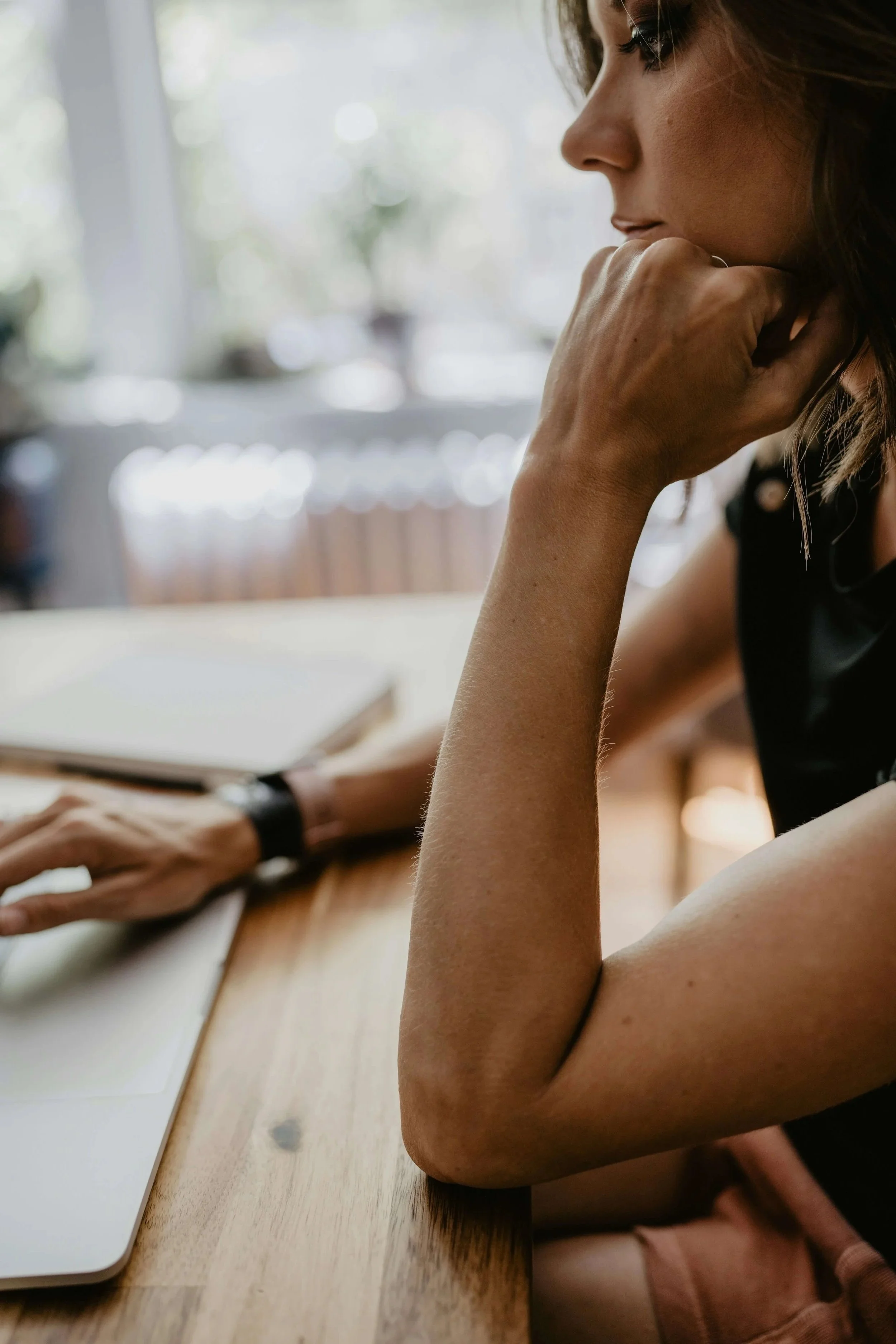 woman sitting at her computer thinking