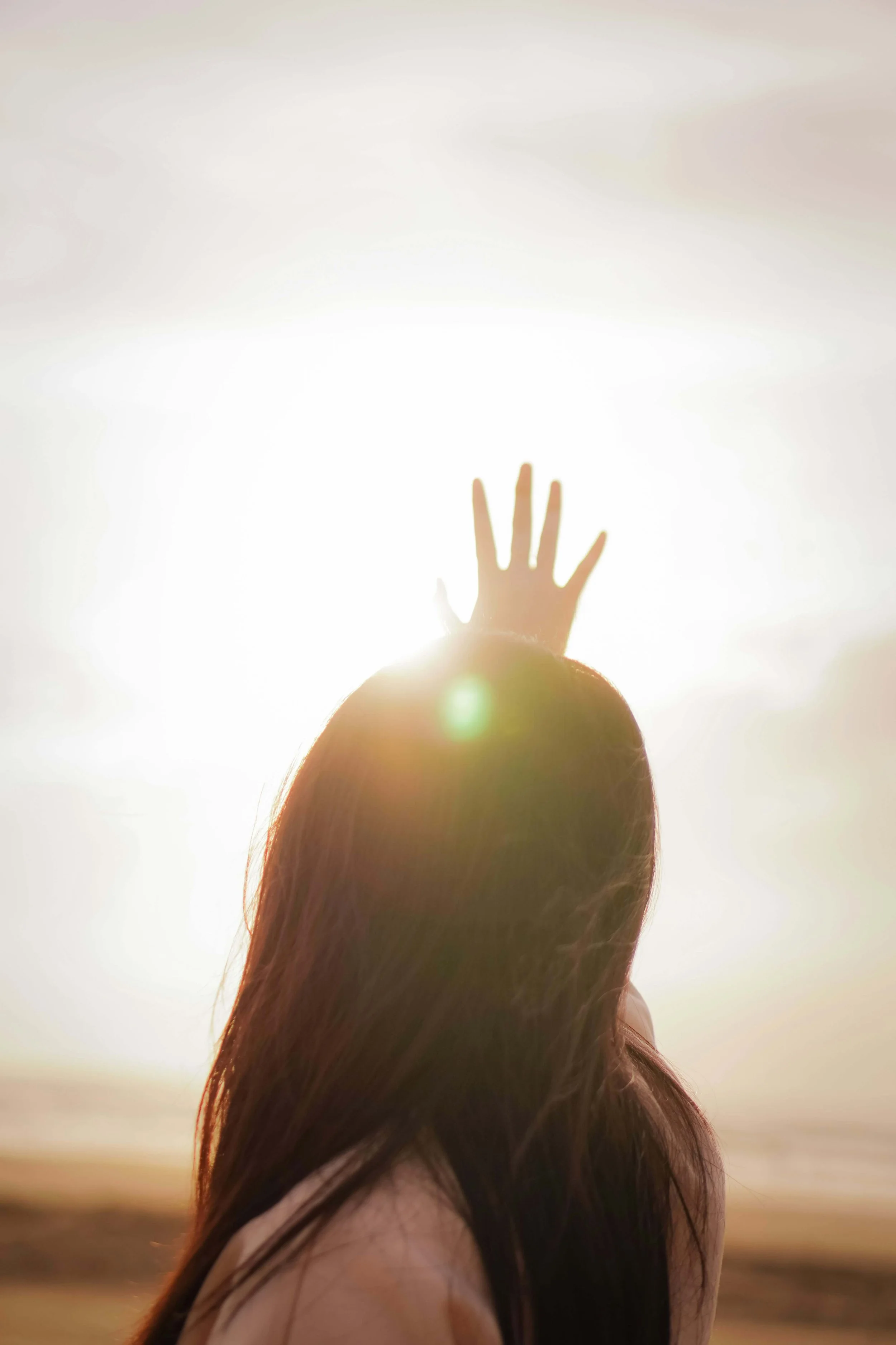 Woman holding her hand up to the sun