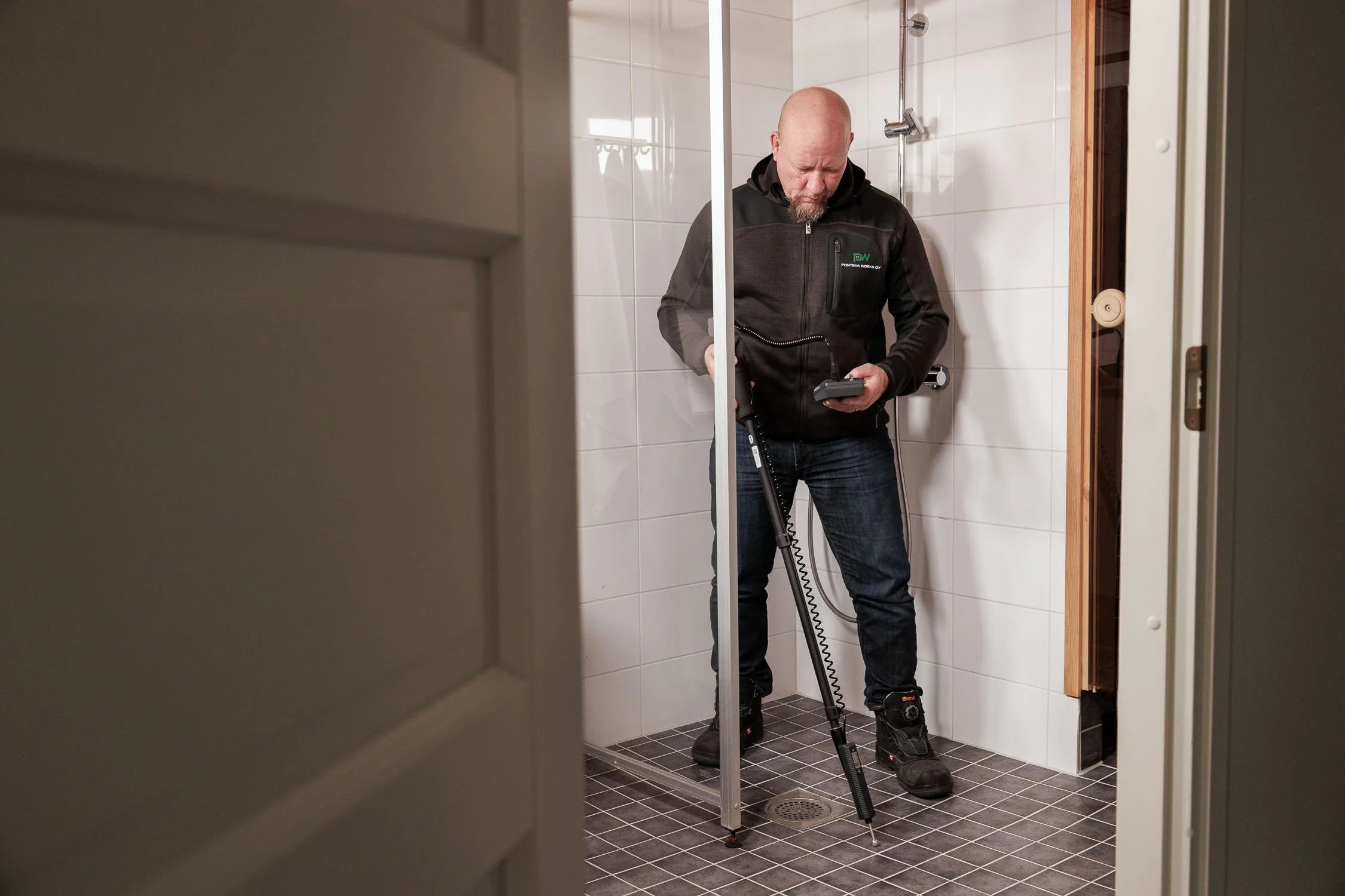Ponteva Works Henri tekemässä kosteuskartoitusta kylpyhuoneessa.