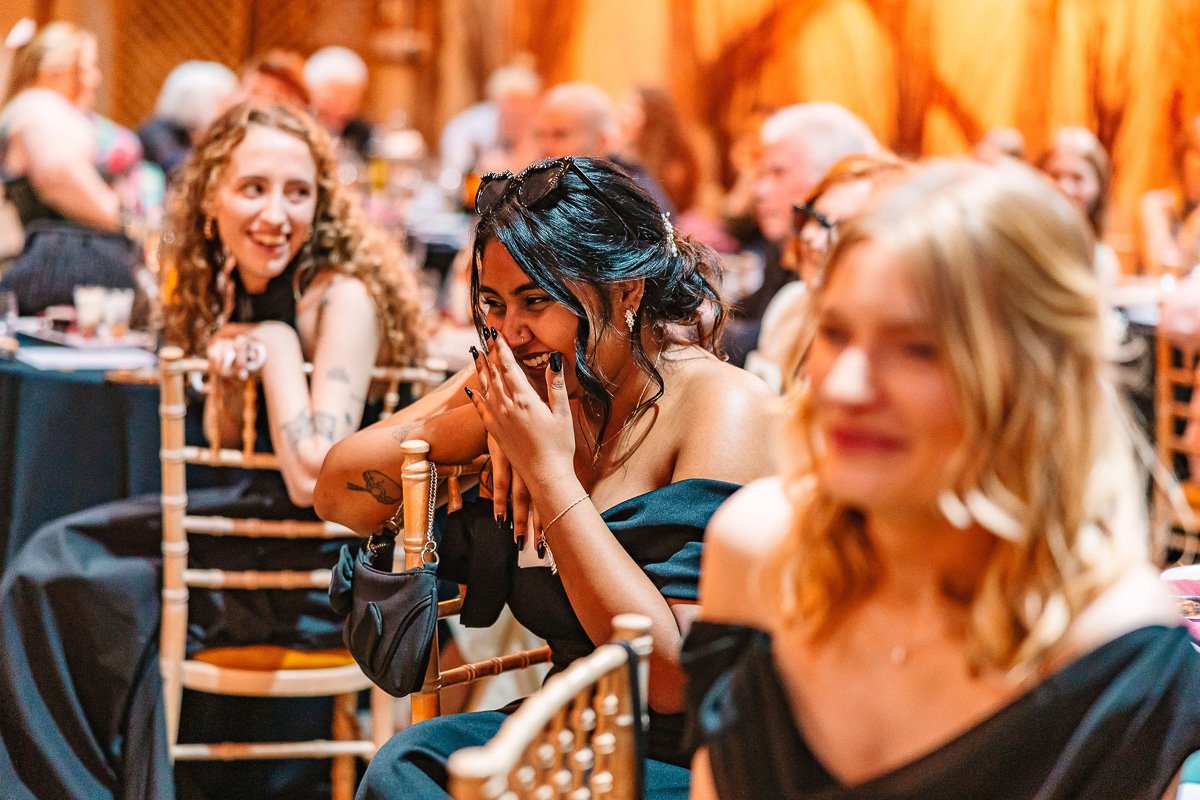  A bridesmaid covers her mouth and laughs during the speeches 