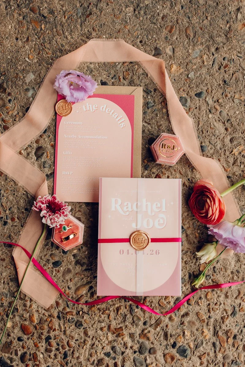  a pastel pink and bright pink stationery suite flatlay   