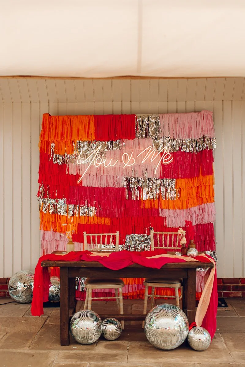 A Colourful Pink and orange disco steamer backdrop wall at Houchins