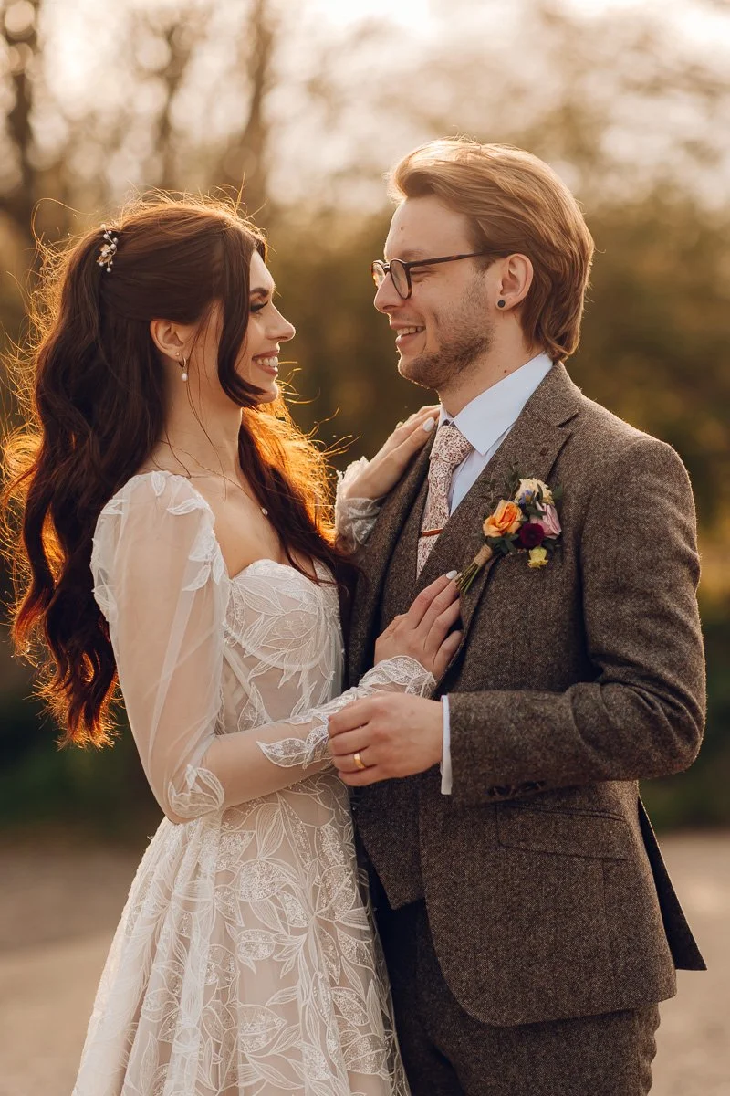 The bride and groom laugh into each other as the golden hour light glows behind them