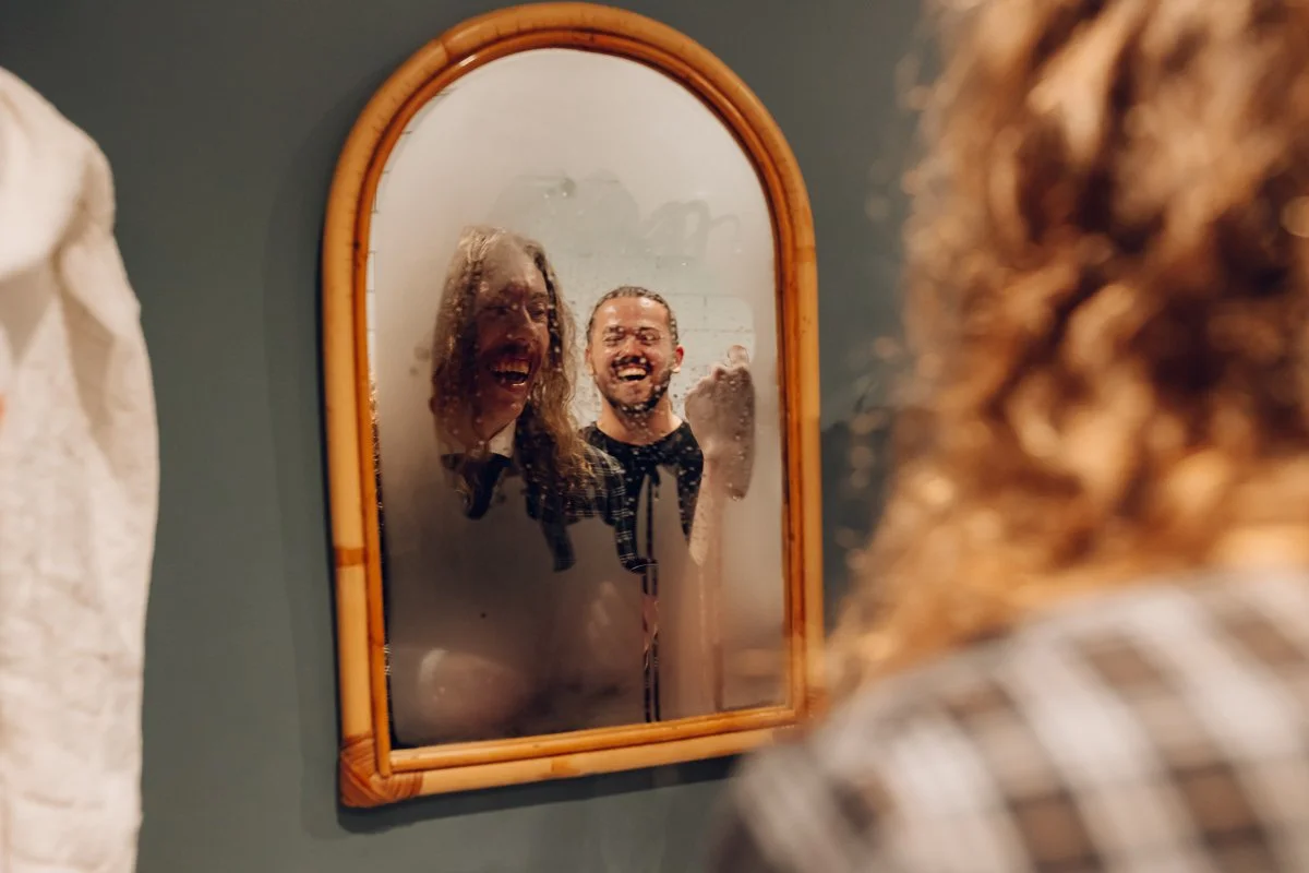 A documentary image of the groom in a mirror covered in condensation