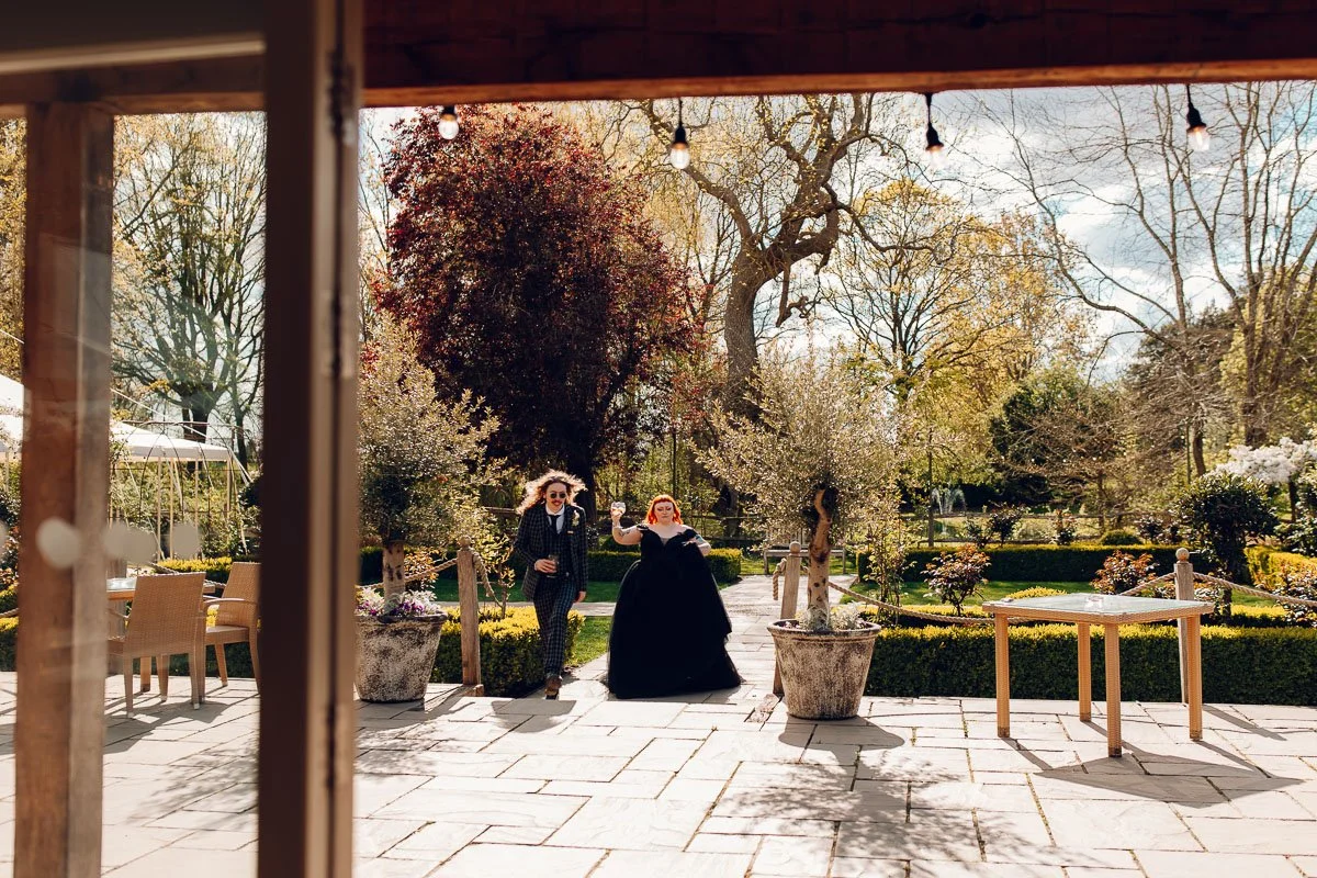 A documentary image of the bride and groom walking towards houchins wedding barn