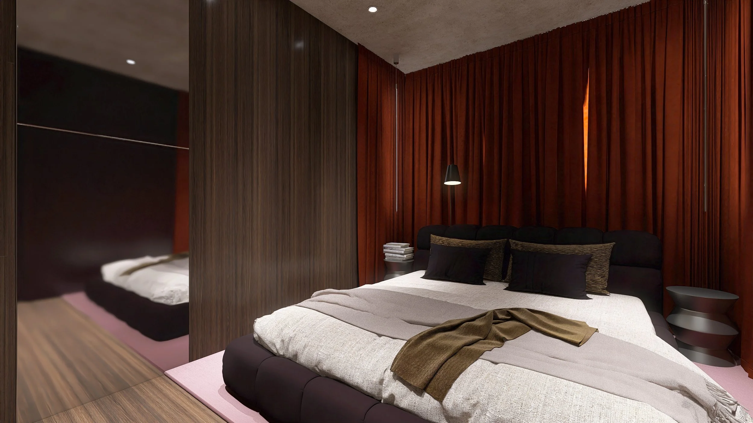 Modernes Schlafzimmer mit dunklem Bett, schwarzen und braunen Kissen, roten Vorhängen, seitlichem Nachttisch mit Büchern und schwarzem Wandlampe. Reflektiert im Spiegel ist ein zweites, kleineres Bett sichtbar.