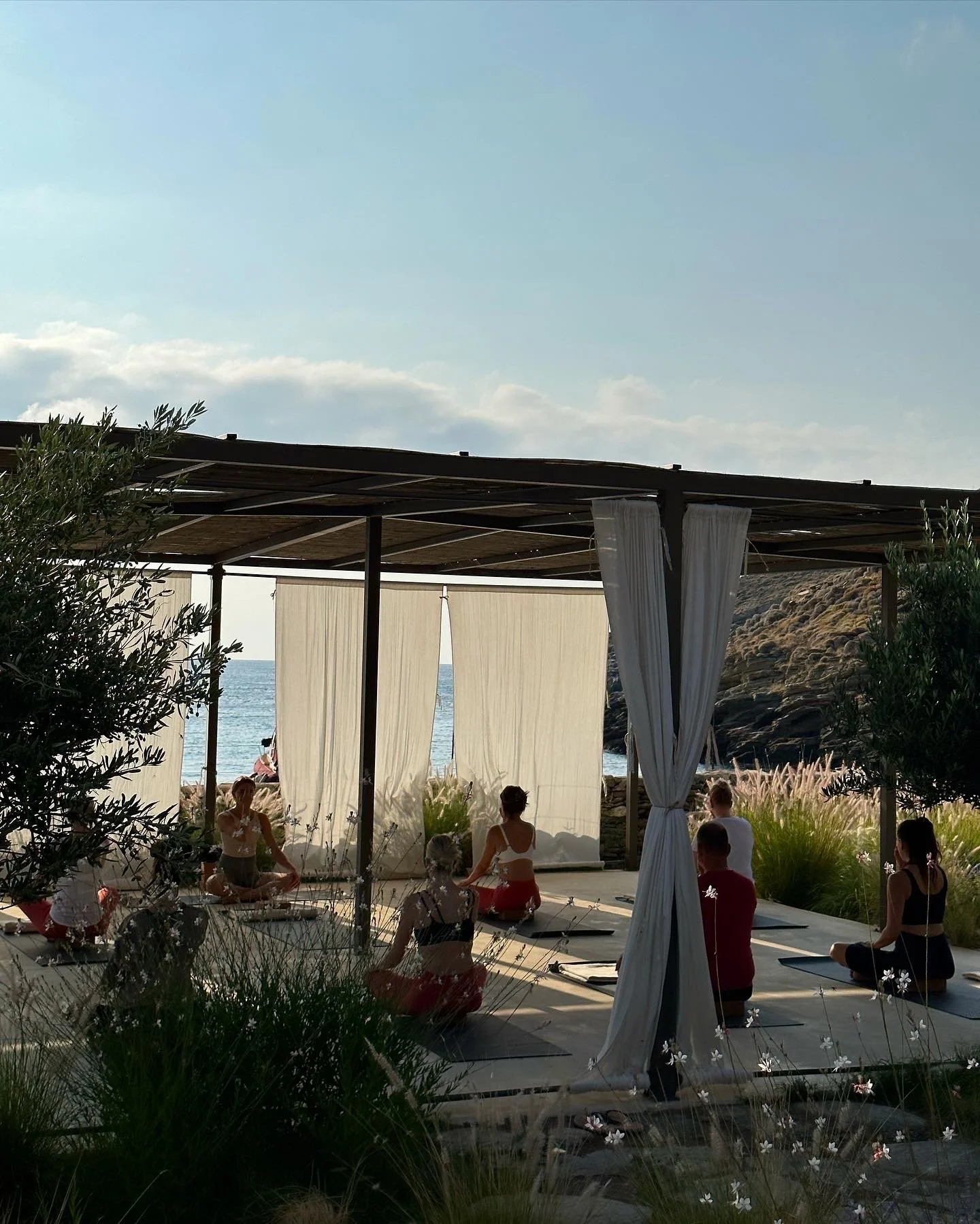 People sitting on yoga mats in outdoor yoga studio