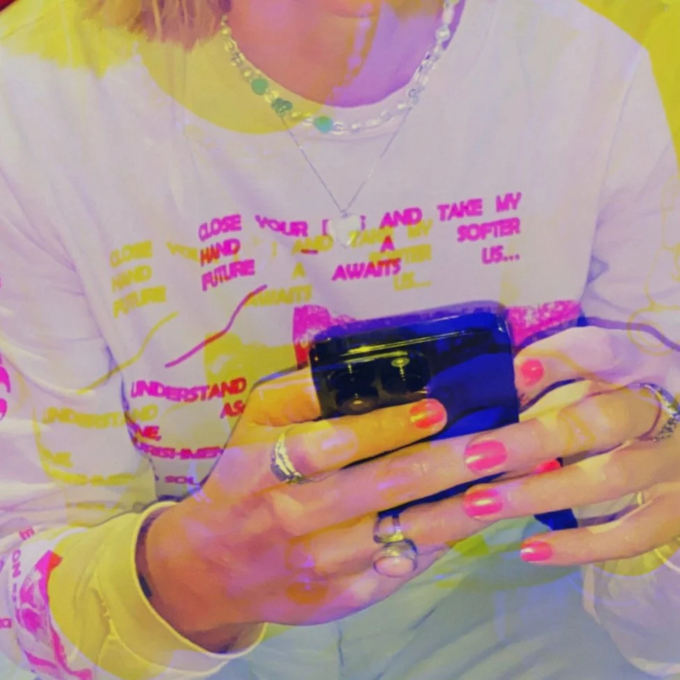 Comedian Freddi Gralle holding a phone and texting insightful, funny ideas.