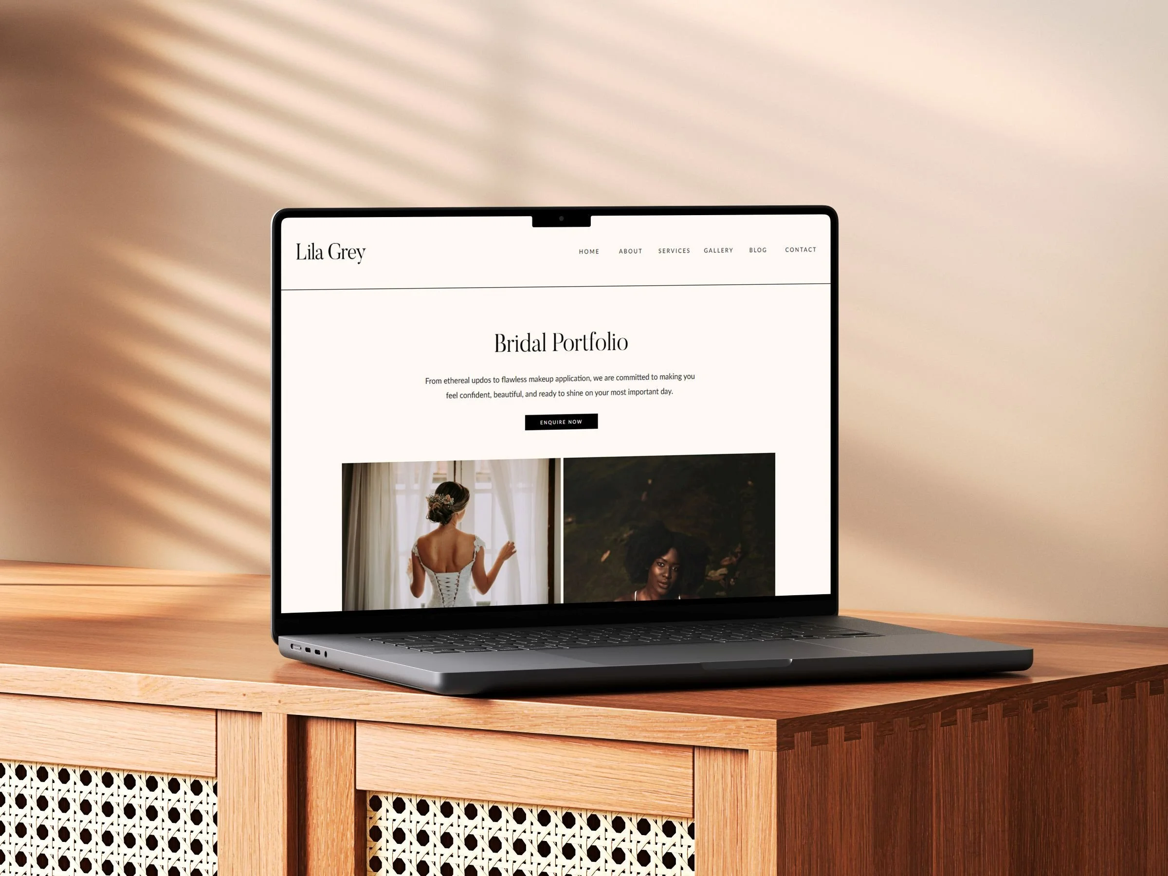 Open laptop on a wooden desk displaying a bridal portfolio website called Lila Grey.
