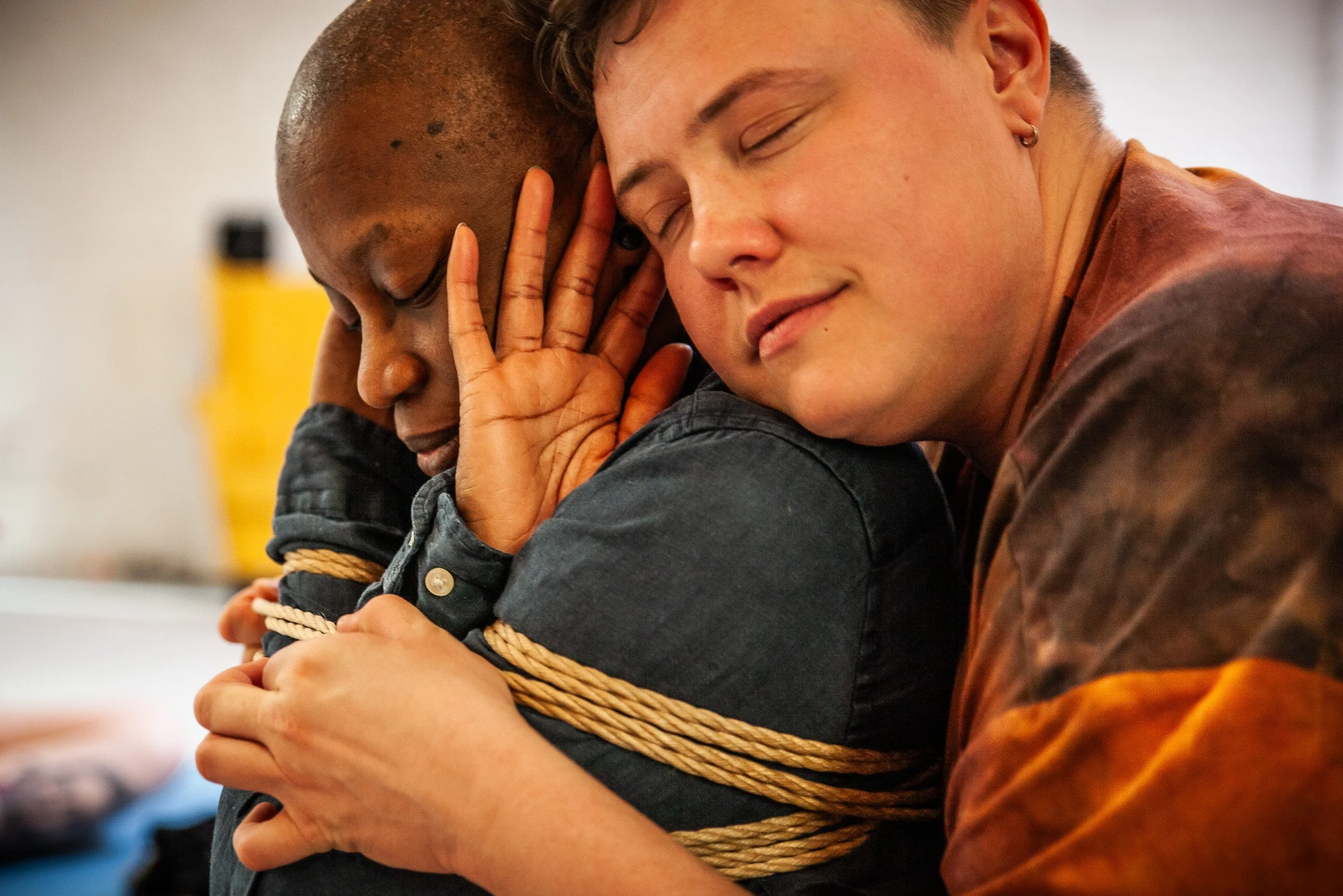 Two women sharing an emotional hug, with one woman consoling the other. The woman on the left appears distressed and is being comforted, while the woman on the right has tears and a gentle expression.