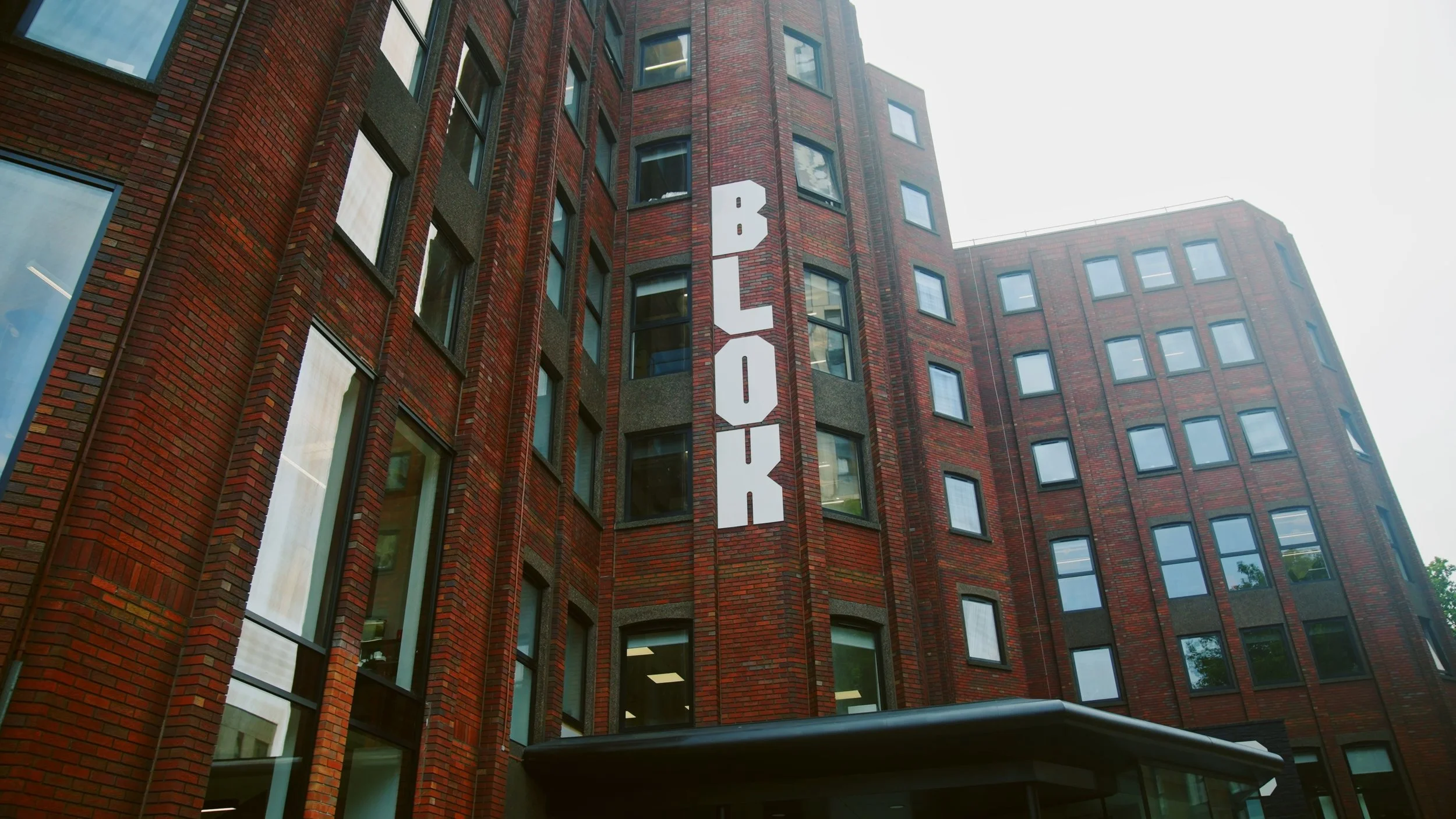 Red brick building with a vertical sign reading 'BLOCK' in large white letters.