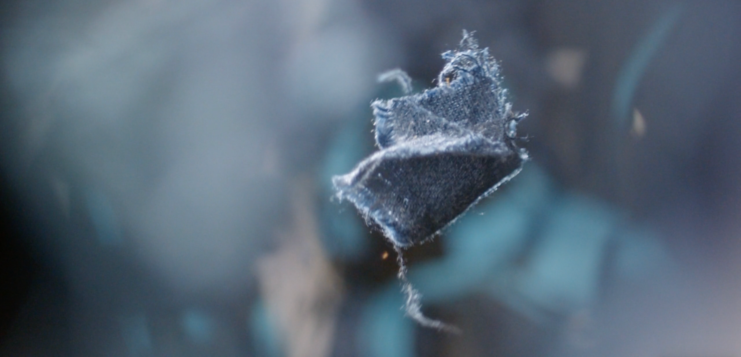 Close-up of a blackened, damaged fabric or material, possibly a burnt or scorched piece of cloth or paper.