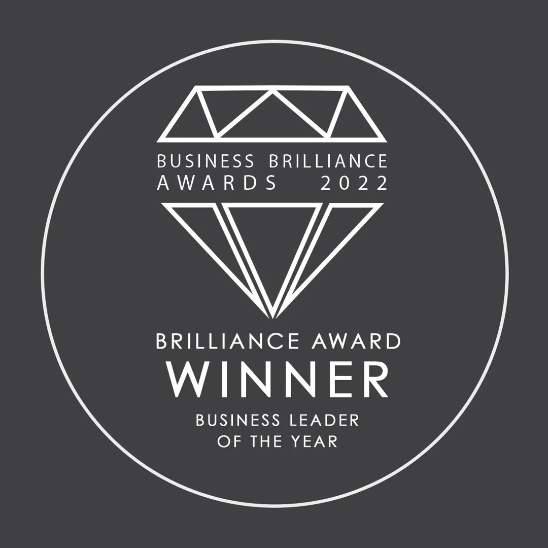 A circular badge for the 2022 Business Brilliance Awards featuring a stylized diamond graphic, with text indicating the award winner is the Business Leader of the Year.