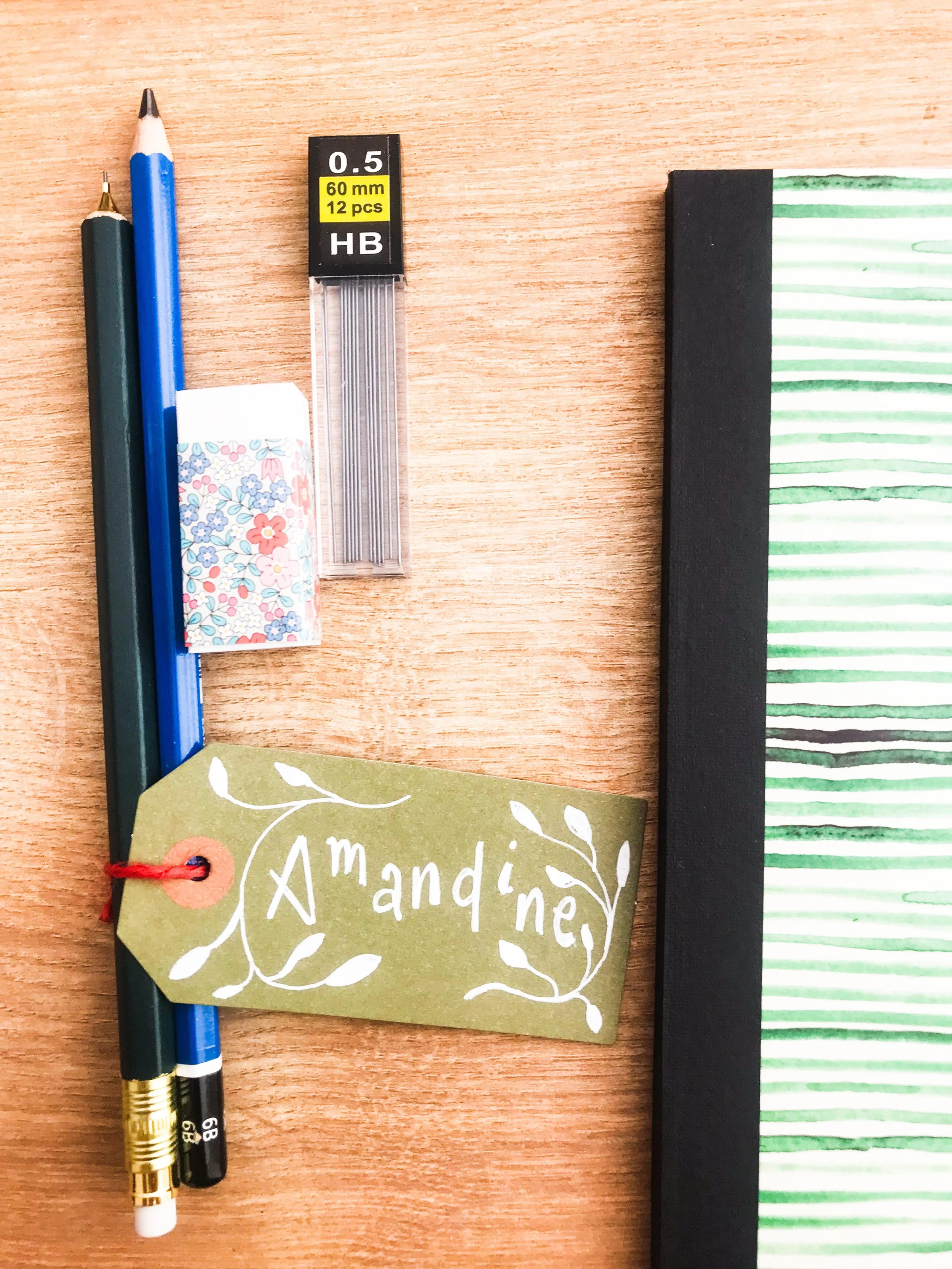 Nametag with the word Amandine on it, with pencils and a booklet