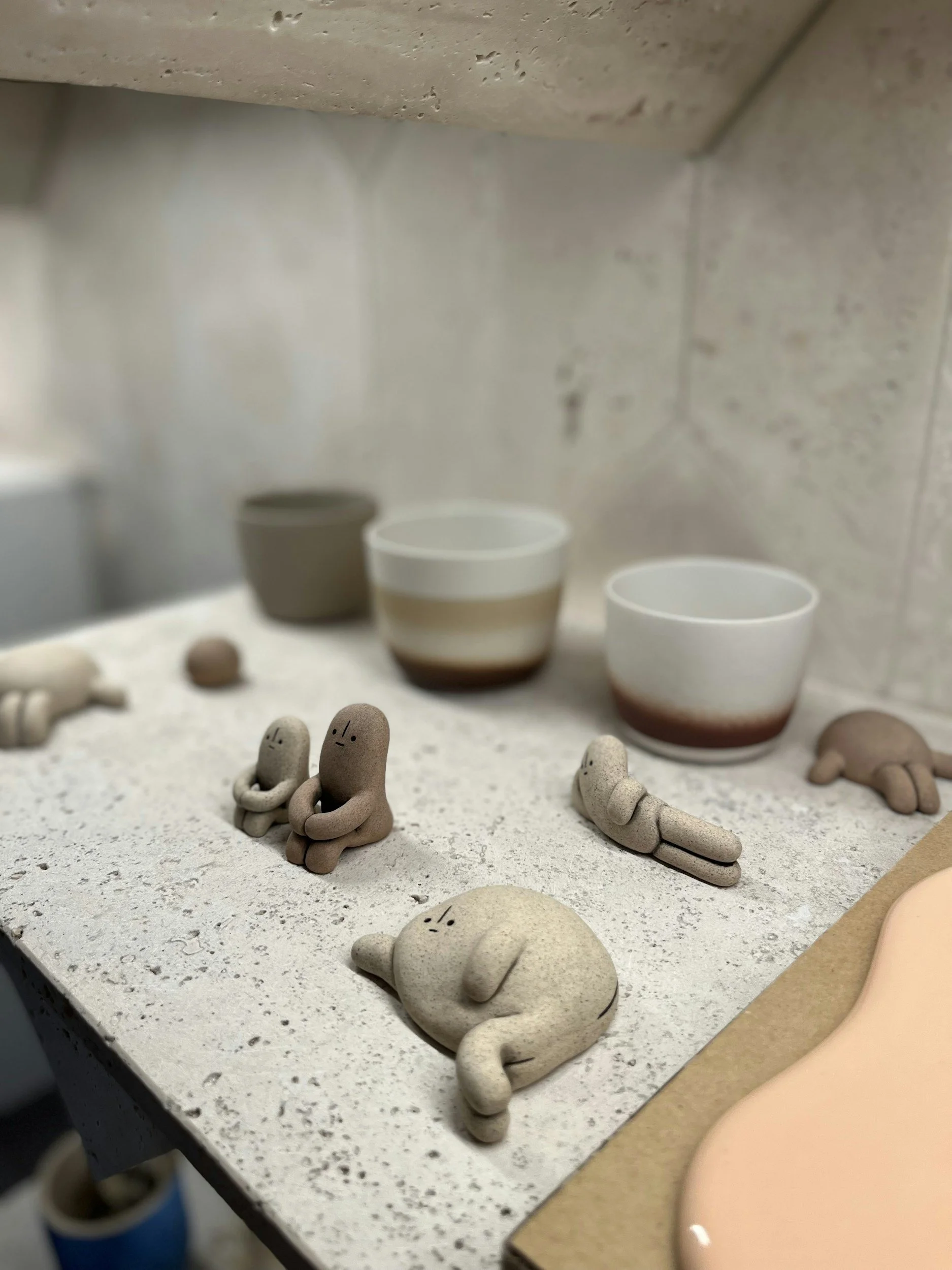 Keramikkunstwerke und Tassen auf einer Werkbank