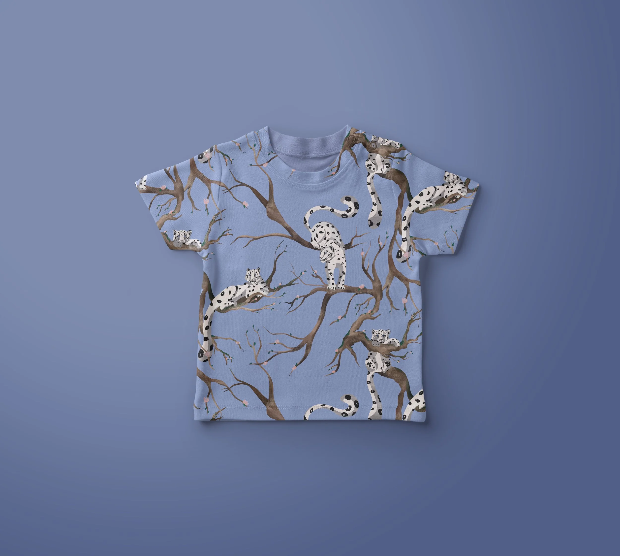 Blue children's T-shirt featuring a pattern of snow leopards and tree branches.