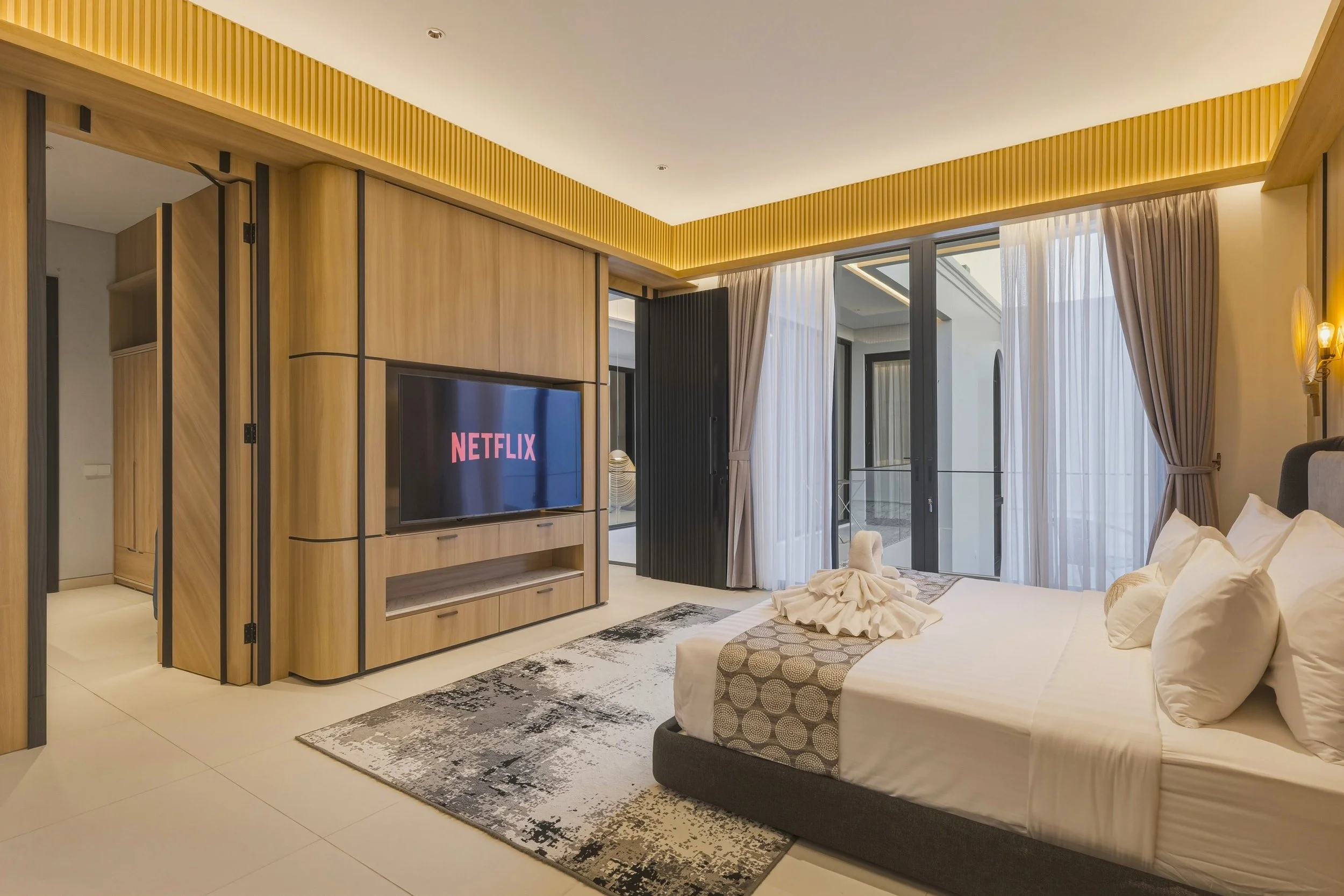 Modern Master bedroom with a 65'' TV plenty natural lights and direct access to the walking closet and master bathroom