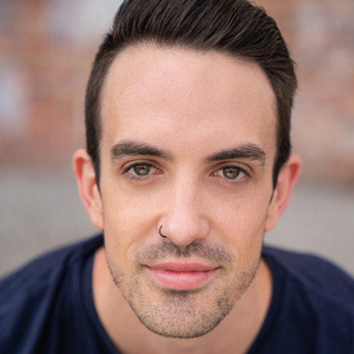 Close-up of a young man with dark hair, tan skin, and a nose piercing, looking directly at the camera.