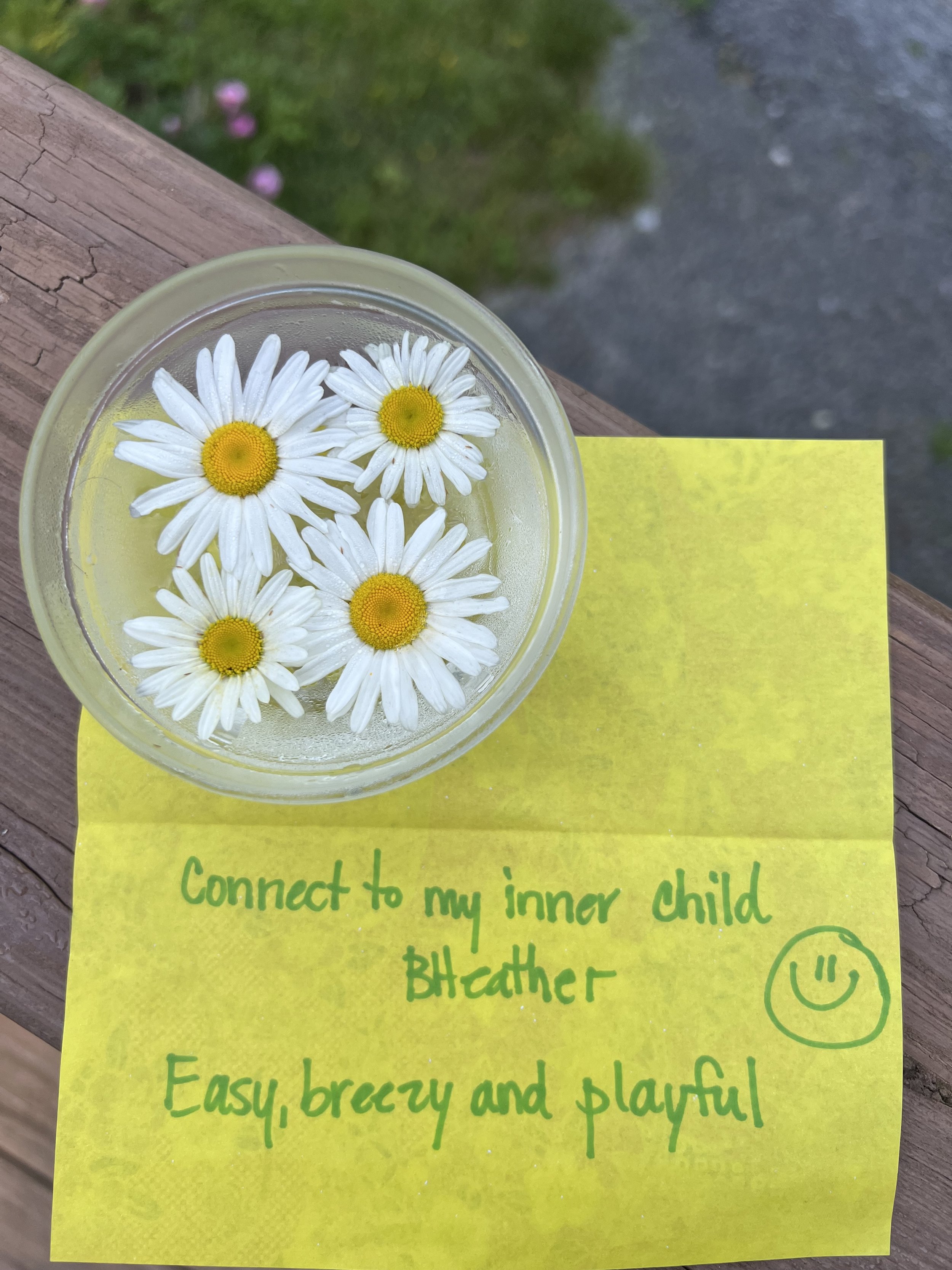 Glass bowl of flower essence infusing in sunlight with a handwritten intention paper set alongside, DIY vibrational healing ritual