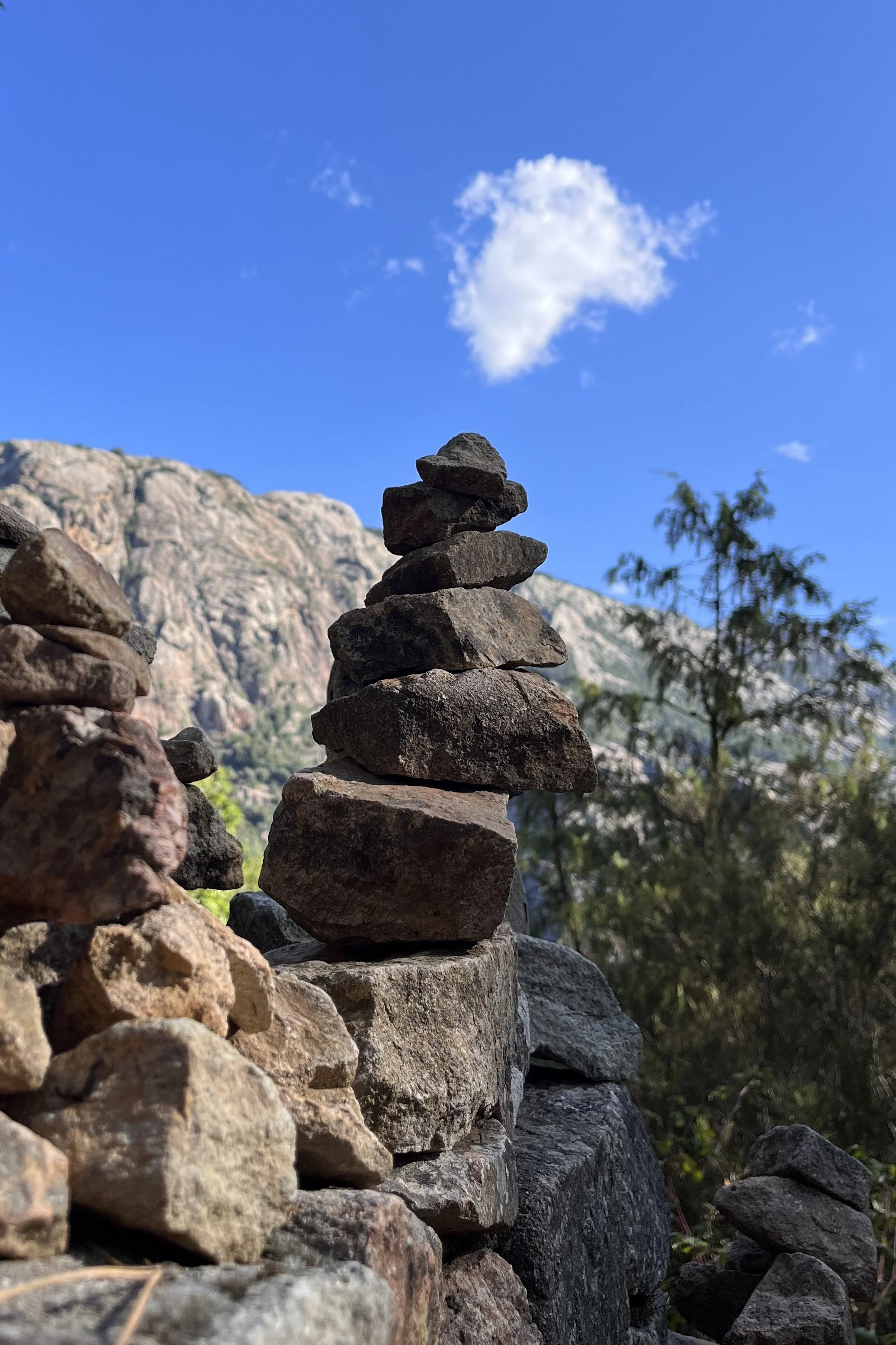 Cairn of stones with mountains in the background