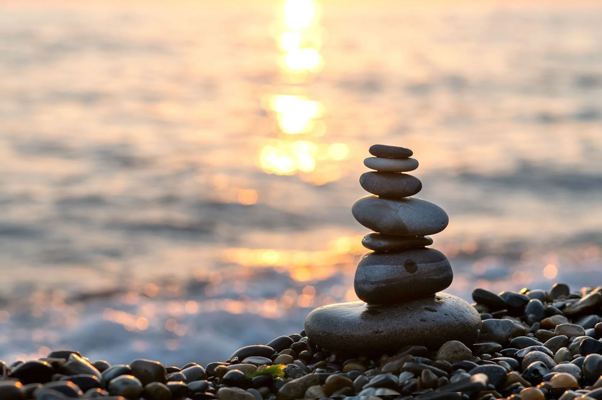 Stacked stones by the sea symbolizing balance and clarity