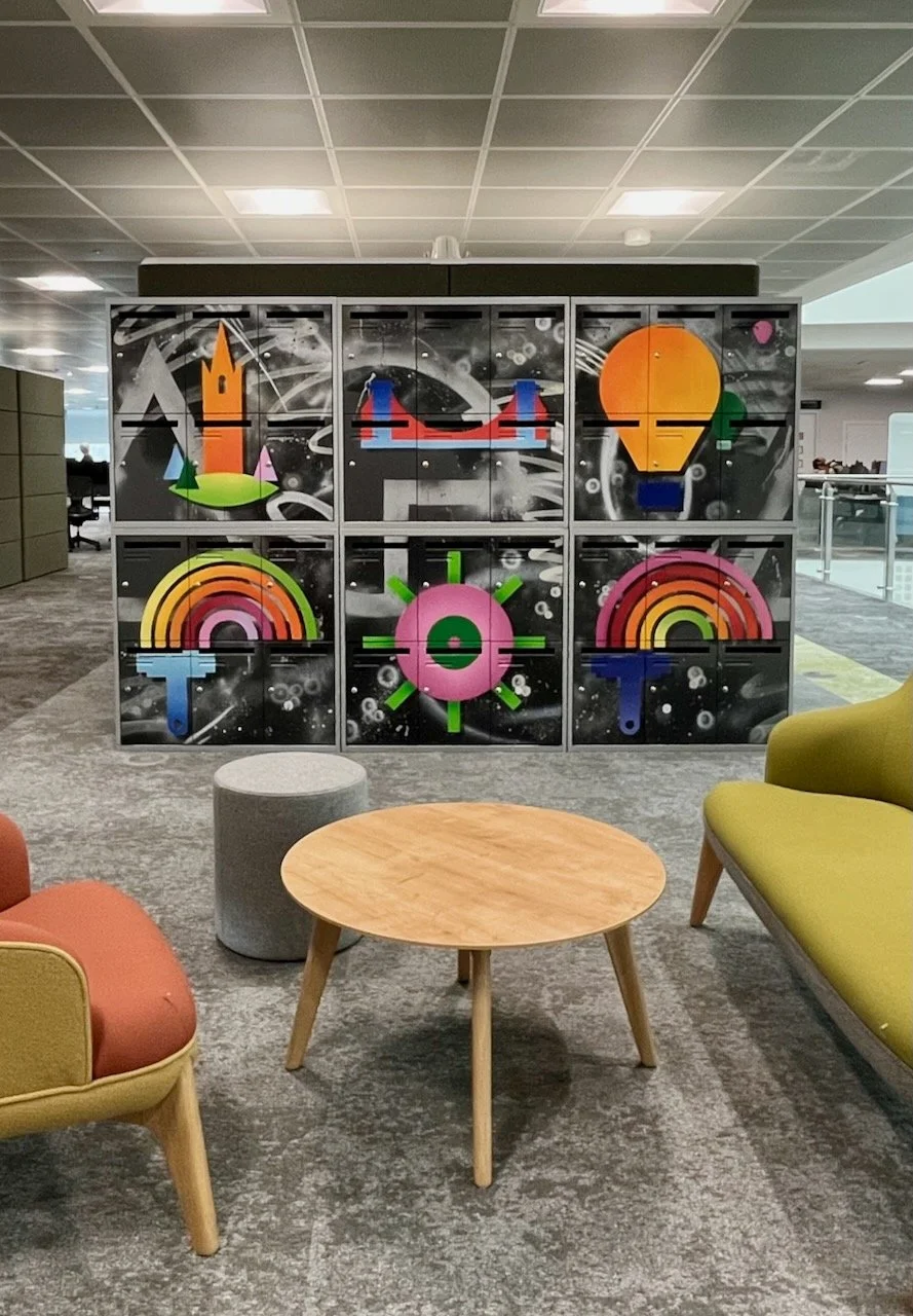 Colorful locker units at Lloyds Banking Group Bristol decorated with vibrant, abstract designs in a modern office or lounge area.