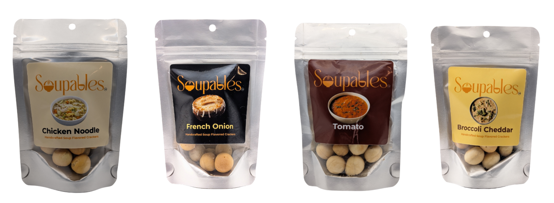 Four transparent resealable snack bags with sliced crackers inside. From left to right: Chicken Noodle, French Onion, Tomato, and Broccoli Cheddar flavors. Each bag has a label with the Soupables logo and flavor name, with images of the respective soups.