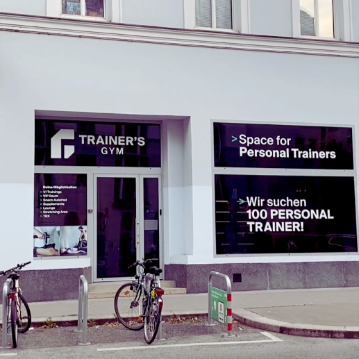 Außenaufnahme eines Fitnessstudios, davor Fahrradständer mit zwei angeschlossenen Fahrrädern