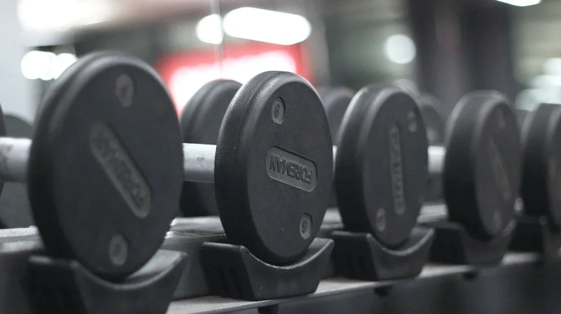 Kurzhanteln auf einem Regal im Fitnessstudio