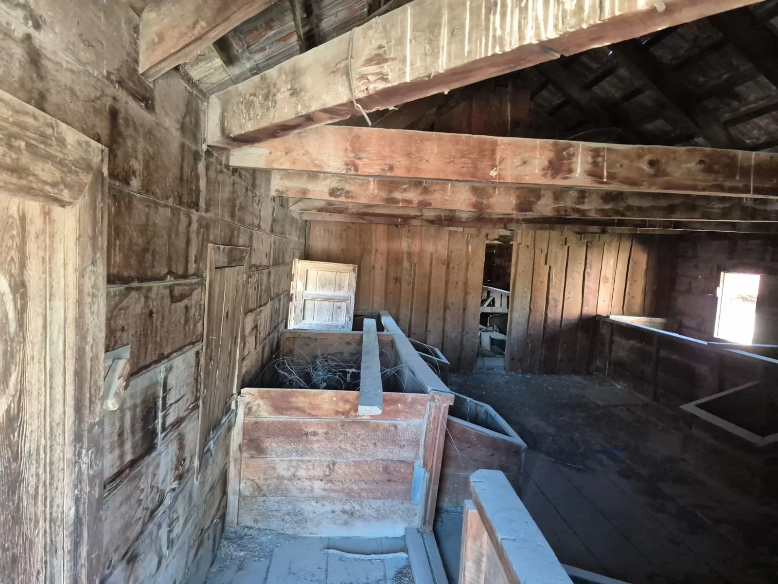 Eski tahta duvarlar ve tavan, pencereden az ışık alan eski bir odanın içi.