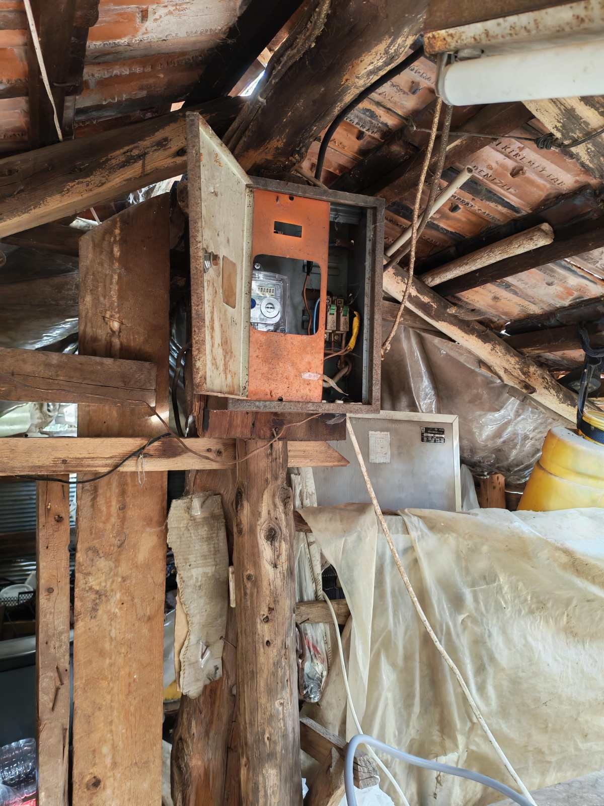 Düzenlenmemiş ahşap ve plastikten yapılmış ahşap tavan tavan arasında eski bir elektrik dağıtım kutusu ve diğer elektriksel ekipmanlar yer alıyor.