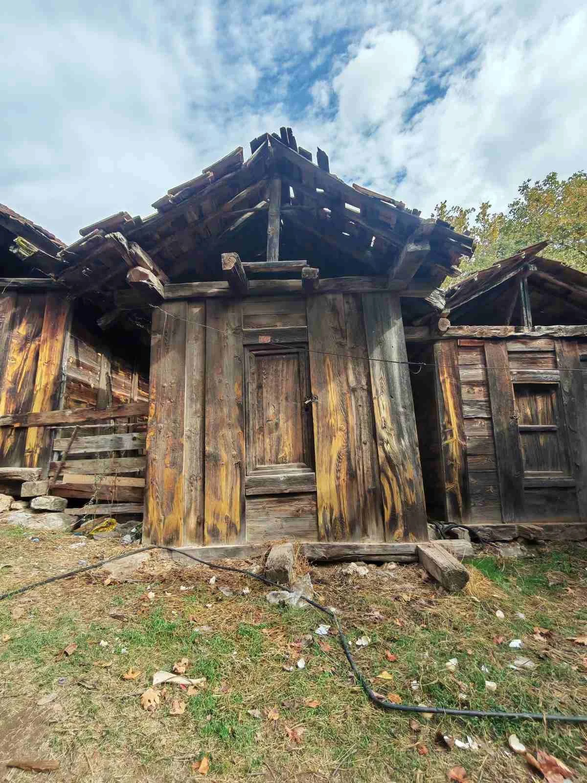 Eski ve yıkık ahşap ev, çatısı ve duvarları zarar görmüş, dış çevresiyle birlikte terkedilmiş durumda.