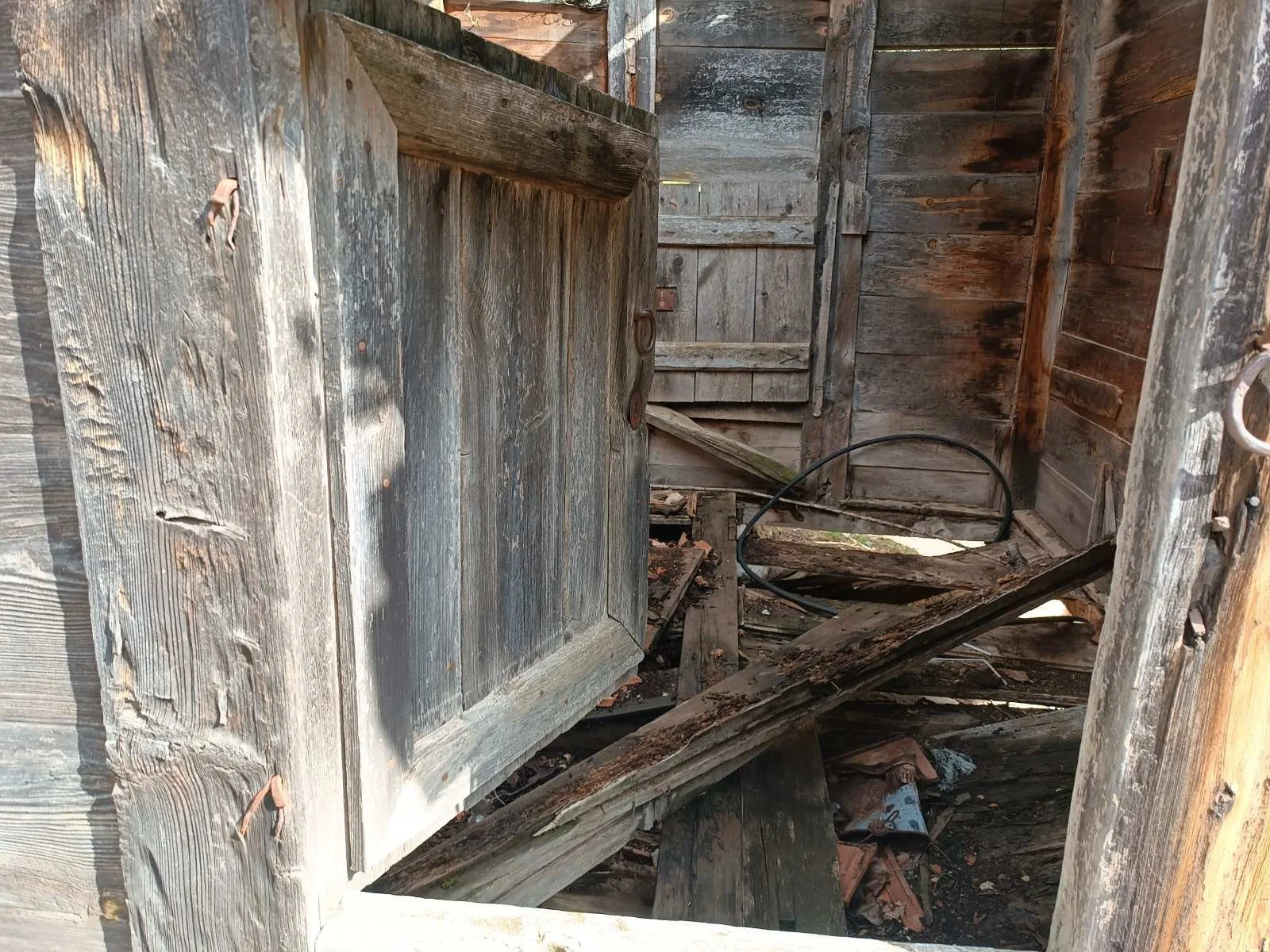 Ahşap duvarlar ve zeminle eski, yıkılmak üzere olan bir yapı.