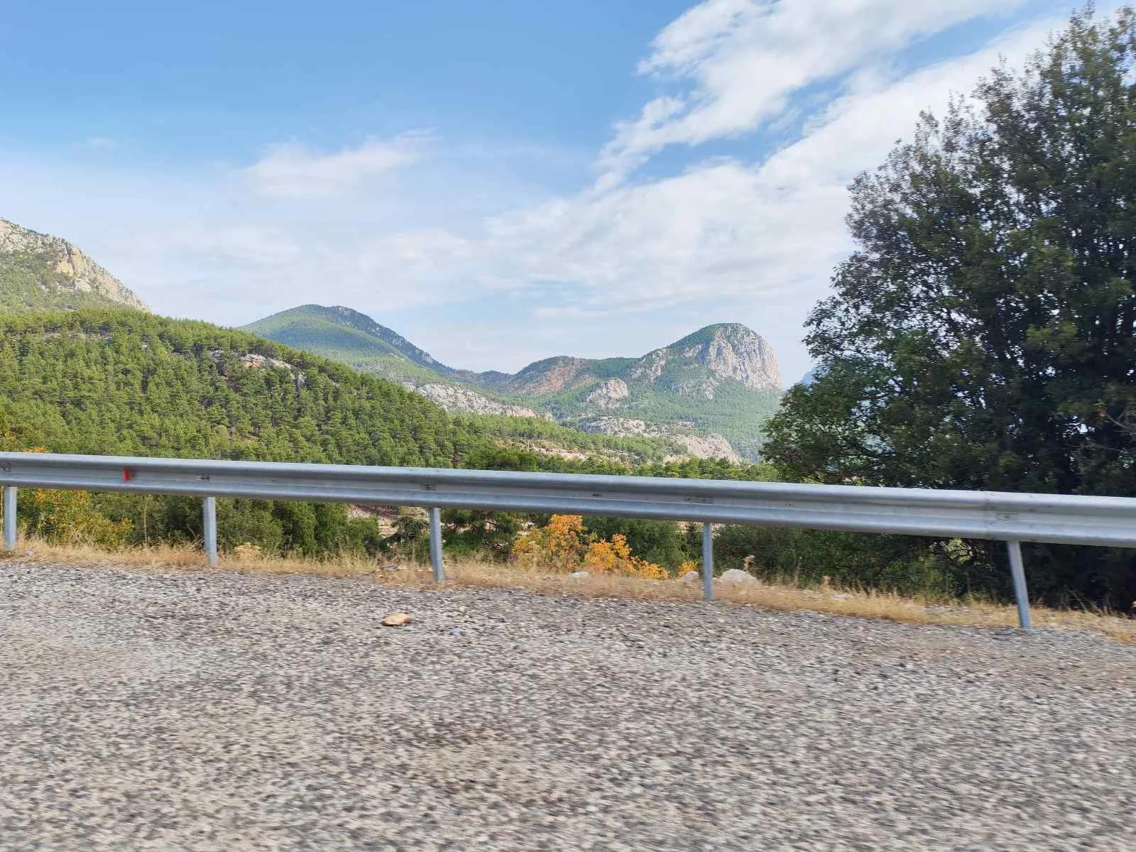 Dağlarla çevrili bir doğa manzarası, yollar ve ağaçlar