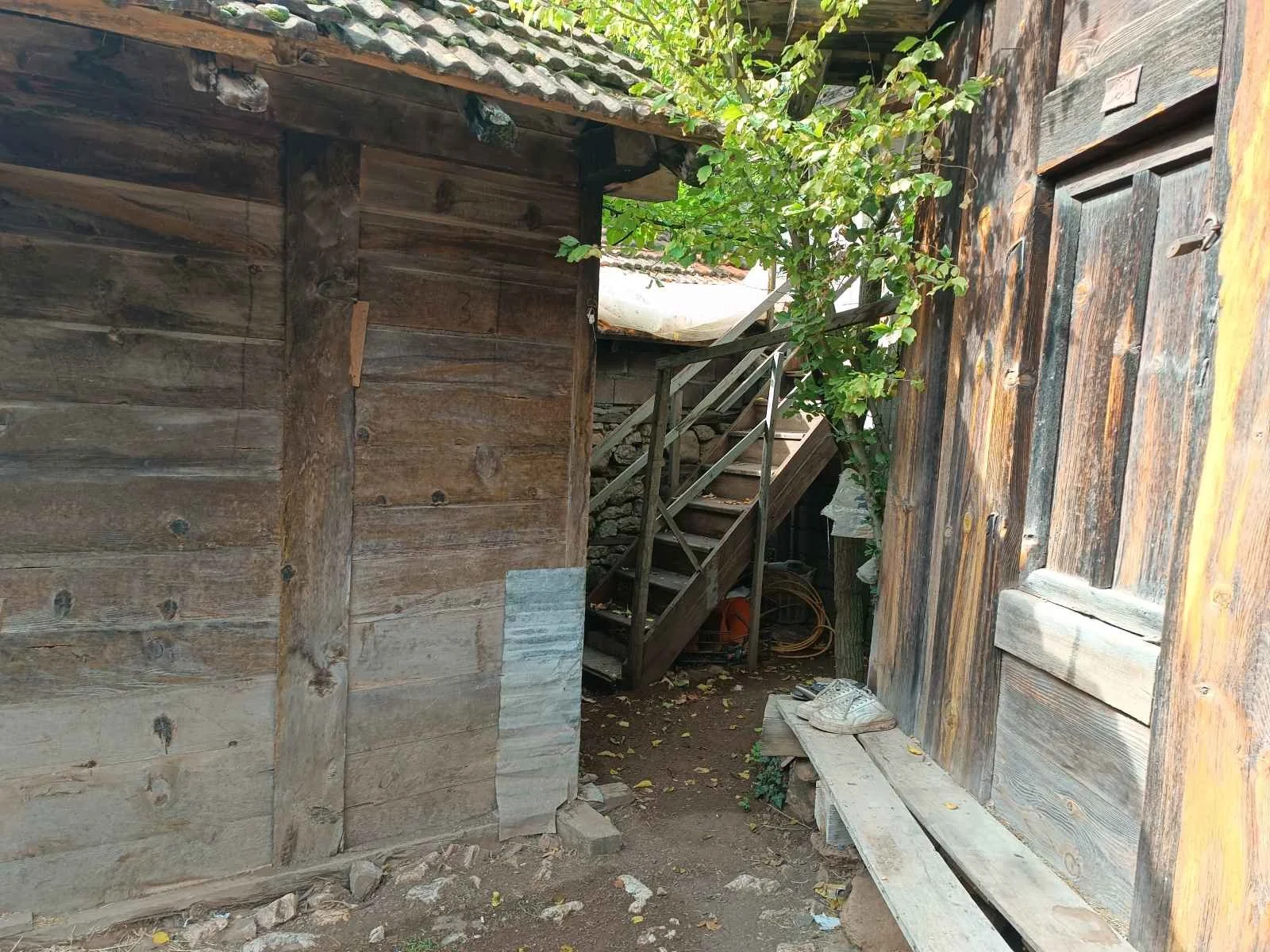 İki ahşap yapı arasındaki dar alanda ahşap merdivenle çıkılan bir oda var, yanarda ağaç ve tahta bir kapı ile çevrili. Yer toprak ve birazda çerçeve var.