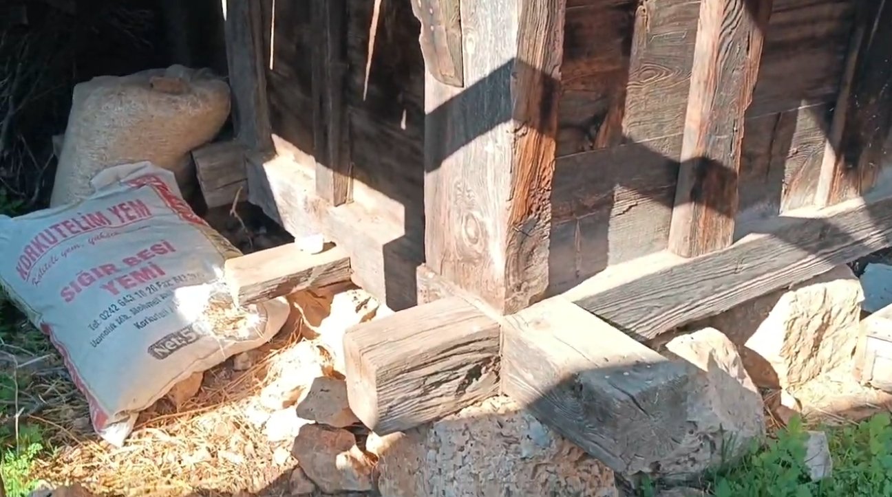 Ahşap yapı üzerine inşa edilmiş, temelini sağlamlaştırmak için yerleştirilmiş taşlar ve odunlar var. Bir kiminin torbaları ve kırık taşlar da etrafta bulunuyor.