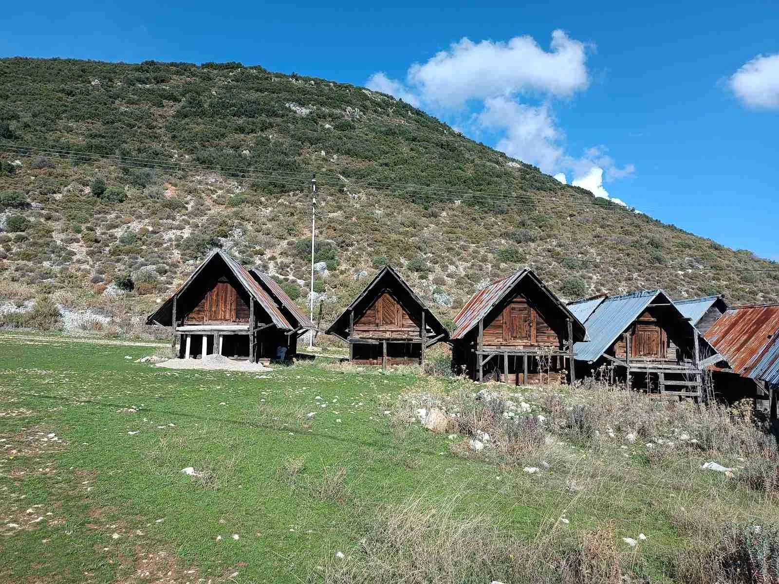 Dağ eteğinde evler, gökyüzü ve bulutlar