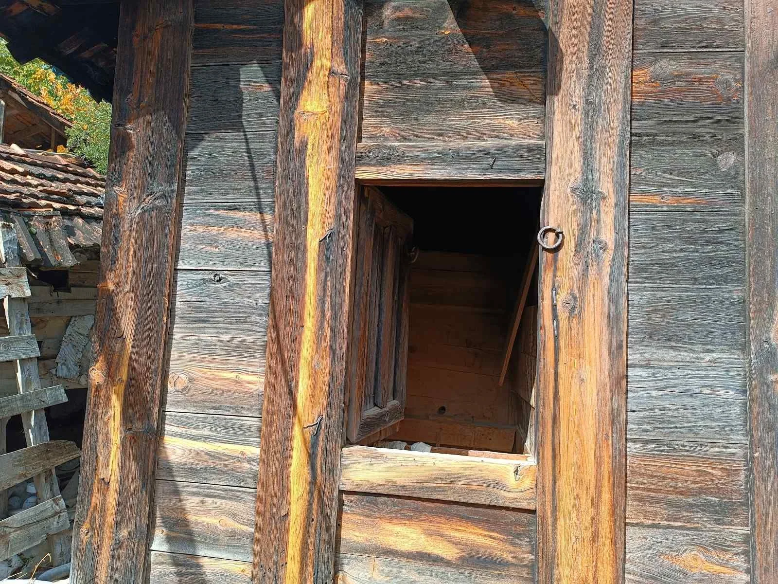 Ahşap eski bir bina veya evin penceresi ve duvarları, bakımlı olmayan ve zamanla aşınmış görünüyor.