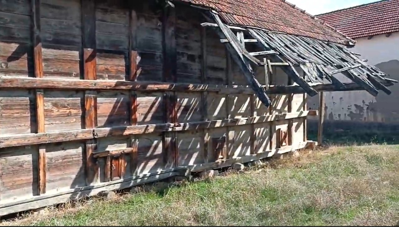 Eski, harabe edilmiş ahşap bir bina ve çatısı kısıtlı, güneş ışığıyla gölgeleri oluşmuş.