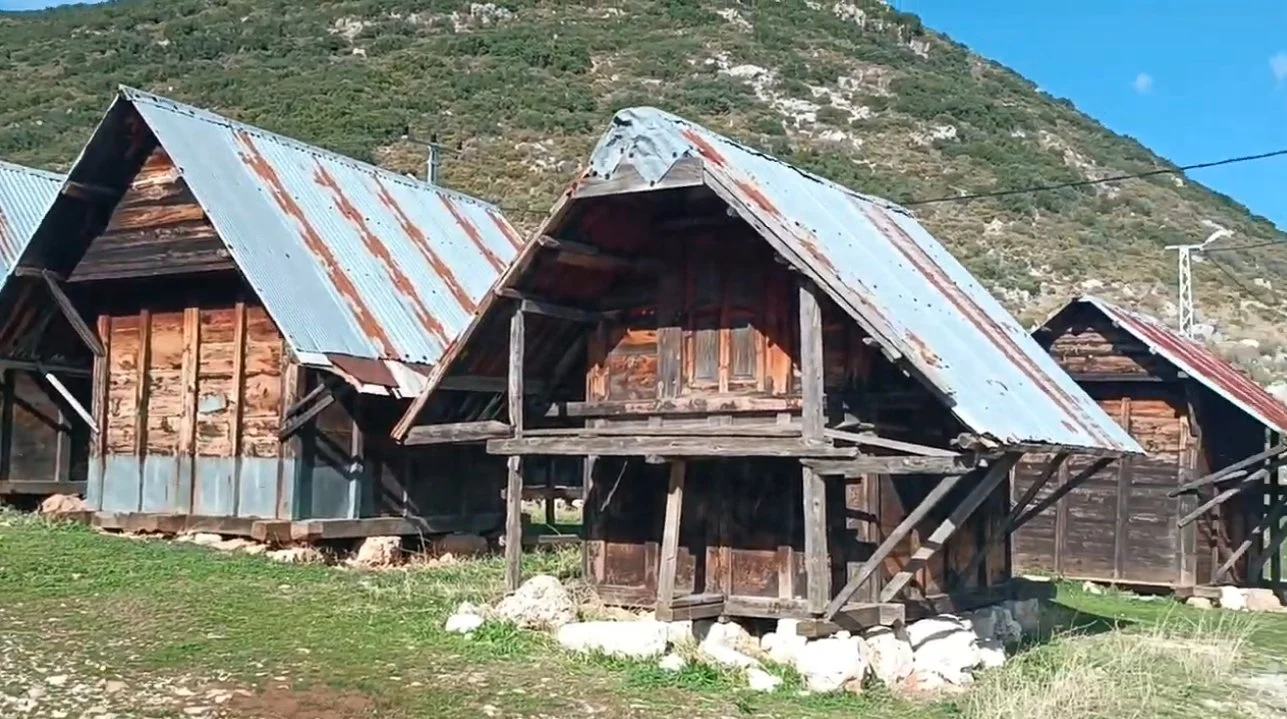 Dağlık alanda birkaç ahşap ve metal çatılı küçük köy evleri.
