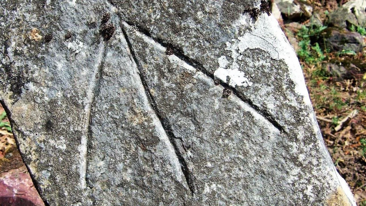 Bir taşın yüzeyinde oyulmuş iki ince ve uzun çizgi.