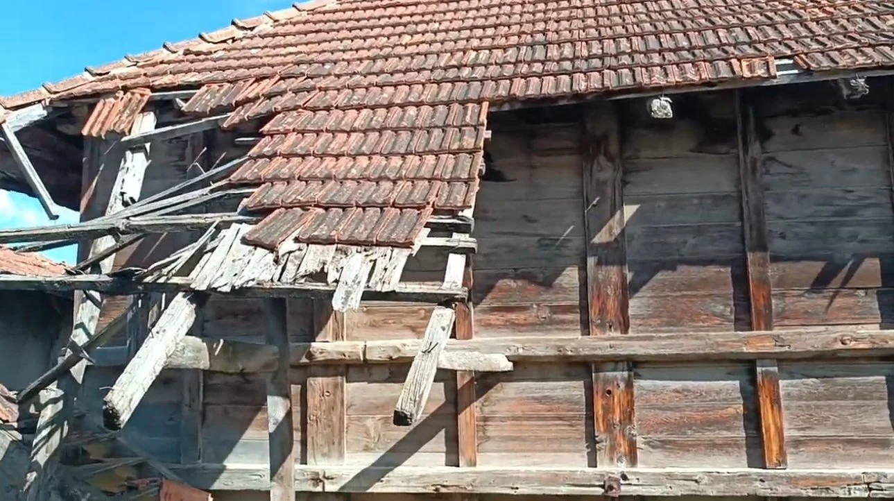 Yıkılmış ve hasar görmüş, eski ahşap ve kiremit çatıyla bir bina.