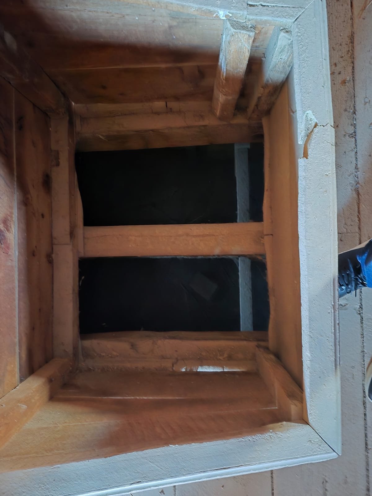 Ahşap çerçeveli bir kutu veya raf. İç kısmında iki bölme ve dış çerçevede ince bir kenar var. Çatı ve duvar görünmüyor.