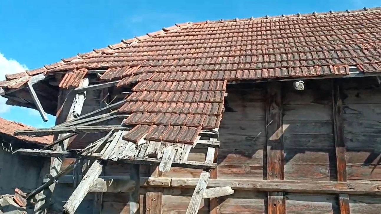 Bakım gerektiren ve hasar görmüş çatısı olan eski ahşap ev.