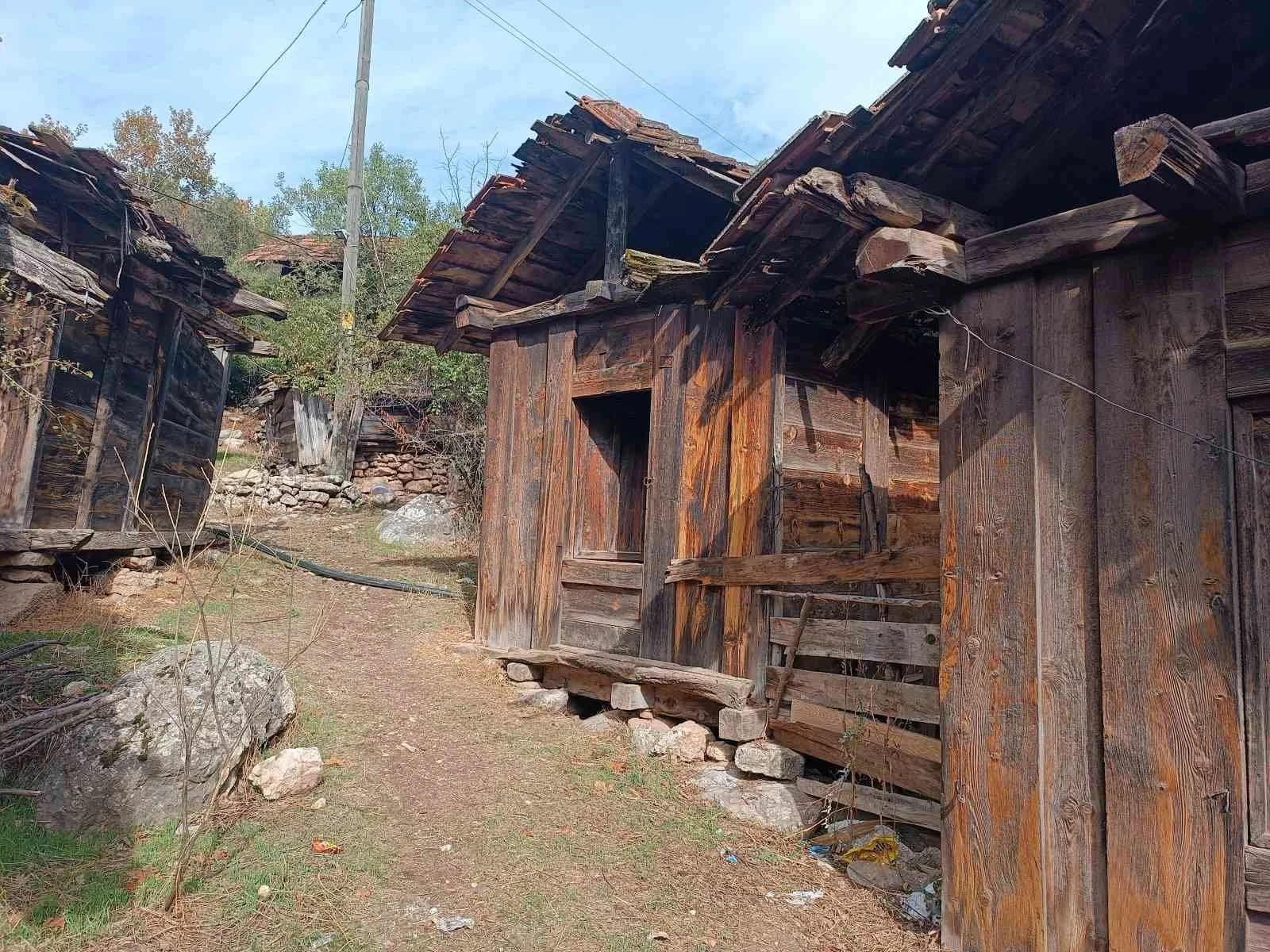 Ahşap ve taş malzemelerden yapılmış, eski, bakımsız ahşap evler ve yol.