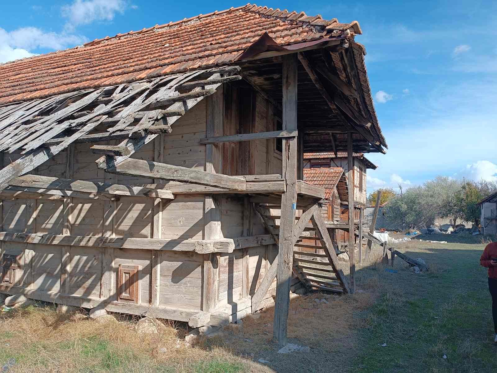 Ahşap ve kiremit çatı with some wooden stairs and a grassy area under a blue sky.