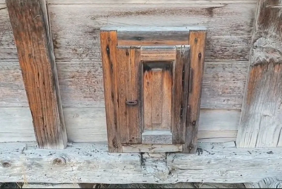 Eski ahşap bir yapıya ait küçük kapak veya pencere kapağı.