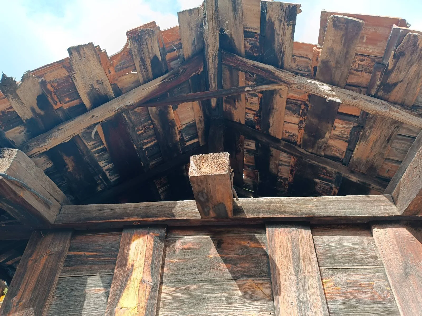Yıkılmış ahşap bir bina çatı yapısı, çatının iç kısmı ve ahşap kirişler görünmekte